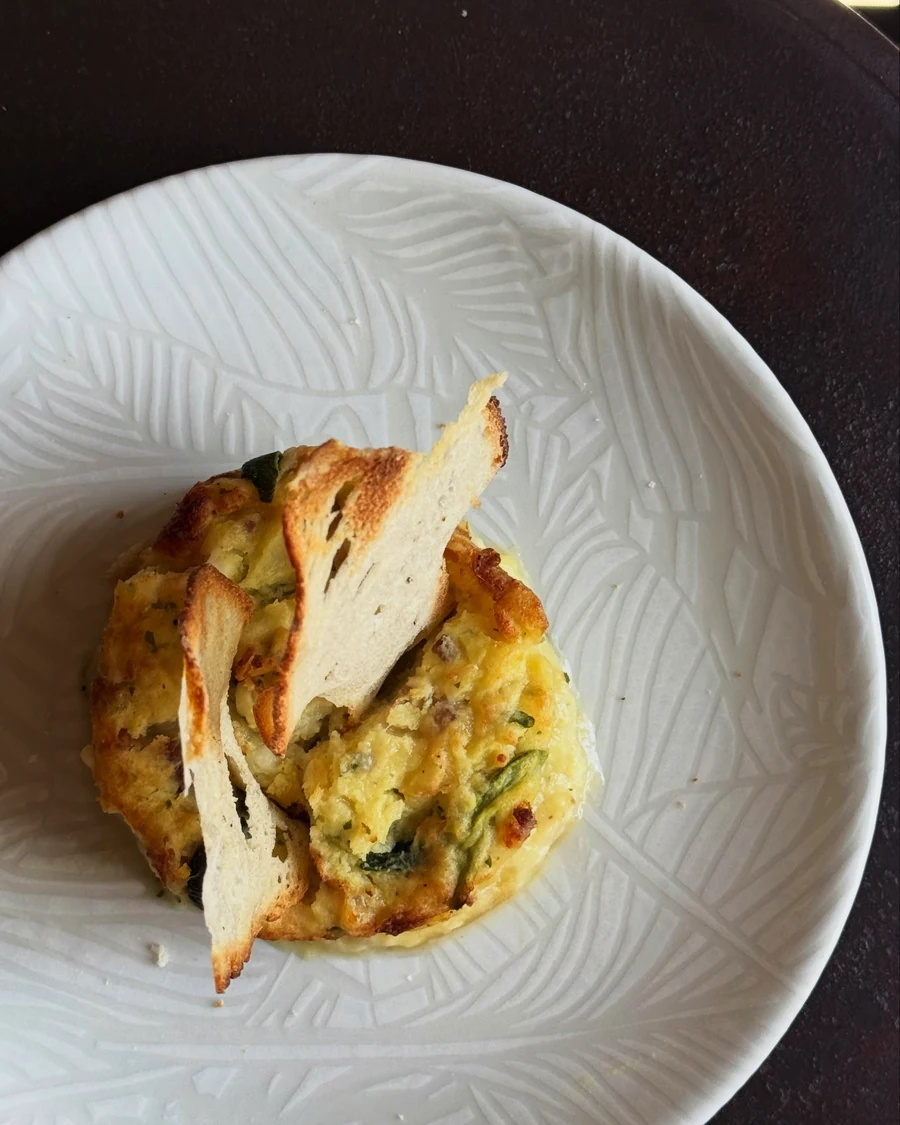 Gateau di patate con zucchine e speck, servito con crostini di pane